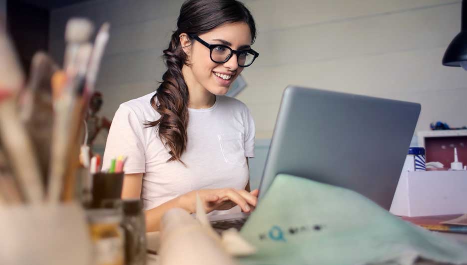 Mulher de óculos teclando no laptop